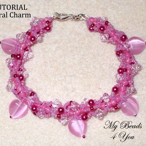 Op de afbeelding: Een handgemaakte roze kralenarmband met hartvormige bedels. De armband heeft een spiraalvormig ontwerp met verschillende roze tinten en heldere kristallen accenten. De tekst "TUTORIAL Spiral Charm" is zichtbaar.