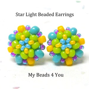 Peut inclure: Boucles d'oreilles en perles Star Light, une paire de petites boucles d'oreilles color&eacute;es avec des perles turquoise, vertes, jaunes et violettes. Les boucles d'oreilles ont la forme d'une fleur.
