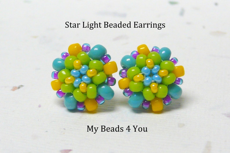 Peut inclure: Boucles d'oreilles en perles Star Light, une paire de petites boucles d'oreilles color&eacute;es avec des perles turquoise, vertes, jaunes et violettes. Les boucles d'oreilles ont la forme d'une fleur.