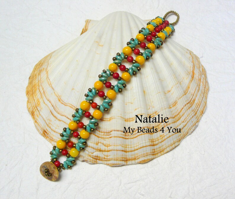 K&ouml;nnte beinhalten: Ein Armband mit gelben, roten und t&uuml;rkisfarbenen Perlen. Das Armband liegt auf einer wei&szlig;en Muschel mit dem Text "Natalie My Beads 4 You".