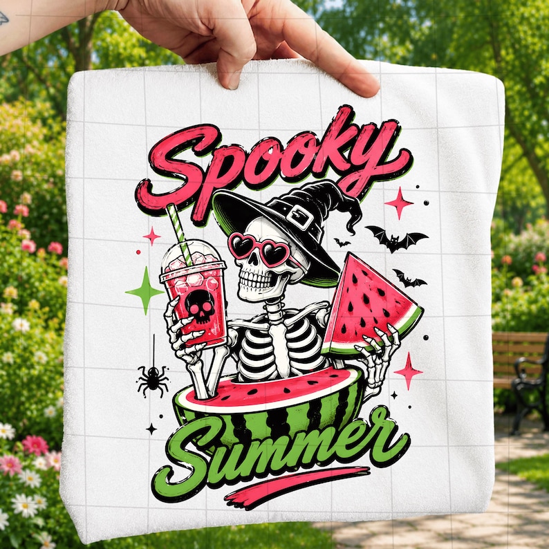 Puede incluir: Una toalla blanca con un gr&aacute;fico de un esqueleto que lleva un sombrero de bruja negro y gafas de sol rosas en forma de coraz&oacute;n. El esqueleto sostiene una bebida rosa con un icono de calavera y una rodaja de sand&iacute;a, sentado dentro de una sand&iacute;a.