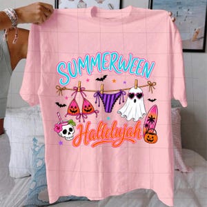 Puede incluir: Una camiseta rosa claro con un gr&aacute;fico que incluye el texto "SUMMERWEEN" y "Hallelujah". El dise&ntilde;o muestra un tendedero con un top de bikini, una braga de bikini y un fantasma con gafas de sol de coraz&oacute;n, adem&aacute;s de una calavera, una tabla y una calabaza.