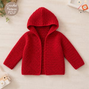 Può includere: Un cardigan rosso acceso a maniche lunghe con cappuccio, realizzato con un punto all'uncinetto testurizzato. Il capo presenta un cappuccio, maniche lunghe con polsini a coste e un'apertura frontale. Un grafico circolare riporta Crochet Pattern PDF.
