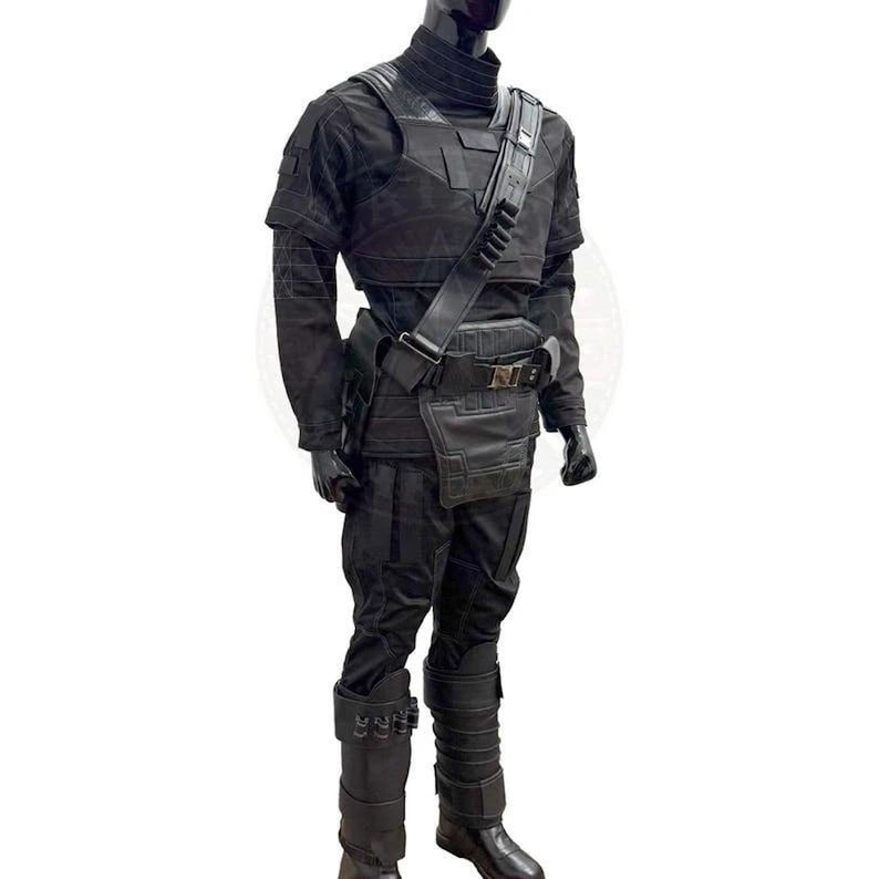 May include: A black tactical costume set featuring a long-sleeved shirt, pants, and a high-neck collar. The outfit includes a structured chest plate, a diagonal shoulder strap with integrated loops, a utility belt with a front pouch, and tall boots.