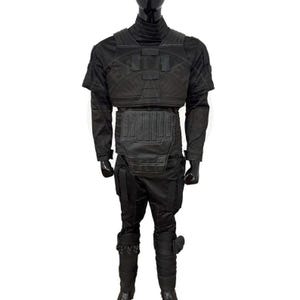 May include: A black tactical uniform set featuring a high-neck long-sleeve shirt, a structured chest plate with rectangular panels, a reinforced abdominal guard, and matching trousers with integrated leg padding and lower shin protective gear.