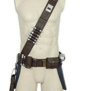 May include: A brown utility belt with multiple pouches, a holster, and a bandolier with silver-tipped bullets. The belt is worn diagonally across the chest. A silver rectangular buckle is on the shoulder strap.
