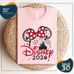 A pink t-shirt with a Disney-themed design, including a bow, fireworks, and a castle, along with the text "Disney 2020". The t-shirt is displayed on a woven basket, and there are two sale signs indicating a 30% discount.