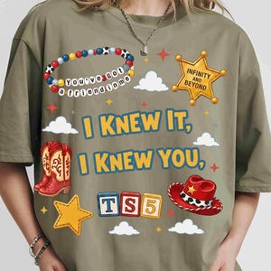 May include: An olive green t-shirt featuring a graphic print with the text "I KNEW IT, I KNEW YOU," a beaded bracelet with the text "YOU'VE GOT A FRIEND IN ME," a gold sheriff badge with "INFINITY AND BEYOND," red cowboy boots, and a red hat.