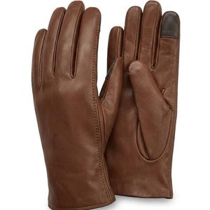 Könnte beinhalten: Ein Paar braune Lederhandschuhe. Die Handschuhe haben eine glatte Textur und sind mit einer Touchscreen-kompatiblen Fingerspitze ausgestattet. Die Handschuhe sind warmbraun und wahrscheinlich für kaltes Wetter.