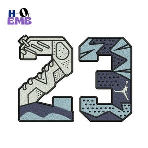 May include: Embroidered patch featuring the number "23" in a sneaker-inspired design. The number is primarily light blue and navy, with a black outline. The iconic Jumpman logo is visible on the right side. The patch includes the text "HO of EMB".