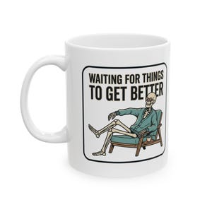 May include: White ceramic mug featuring a cartoon skeleton in a teal sweater, relaxing in a chair with a coffee cup. The mug has the text "WAITING FOR THINGS TO GET BETTER" in a black, bold font.