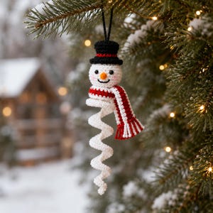 May include: A crocheted snowman ornament featuring a black top hat with a red band, a white head with a small orange nose and black eyes, and a red and white striped scarf. The body consists of a long, white, spiralling tail hanging downwards.