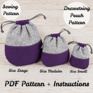May include: Three drawstring pouches in large, medium, and small sizes. Each pouch features a grey upper section with a white floral pattern and a solid purple lower section. The text reads Sewing Pattern, Drawstring Pouch Pattern, Size Large, Size Medium, Size Small, and PDF Pattern + Instructions.