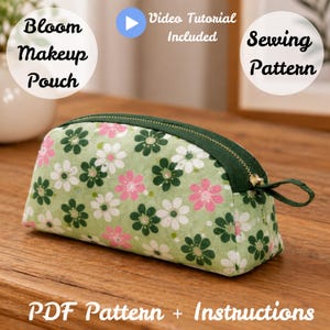 May include: A green floral makeup pouch with a dark green zipper and pull. The pouch is covered in a pattern of pink, white, and dark green flowers. Text on the image reads "Bloom Makeup Pouch", "Video Tutorial Included", "Sewing Pattern", and "PDF Pattern + Instructions".