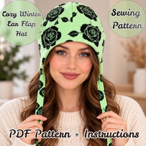 May include: A lime green ear flap hat featuring a black rose floral pattern. The text on the image reads Cozy Winter Ear Flap Hat, Sewing Pattern, and PDF Pattern + Instructions. The hat has long side flaps hanging down from the sides.