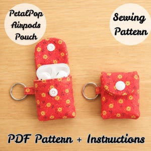 May include: Two red fabric pouches with a yellow floral pattern, each featuring a white snap closure and a silver metal keyring. One pouch is open, revealing white wireless earbuds inside. Text reads PetalPop Airpods Pouch Sewing Pattern PDF Pattern + Instructions.