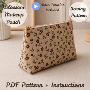 Puede incluir: Un neceser beige con un estampado floral de flores marrones y hojas verdes. El neceser tiene una cremallera dorada y el texto "Blossom Makeup Pouch" y "PDF Pattern + Instructions". Se incluye un tutorial en vídeo.