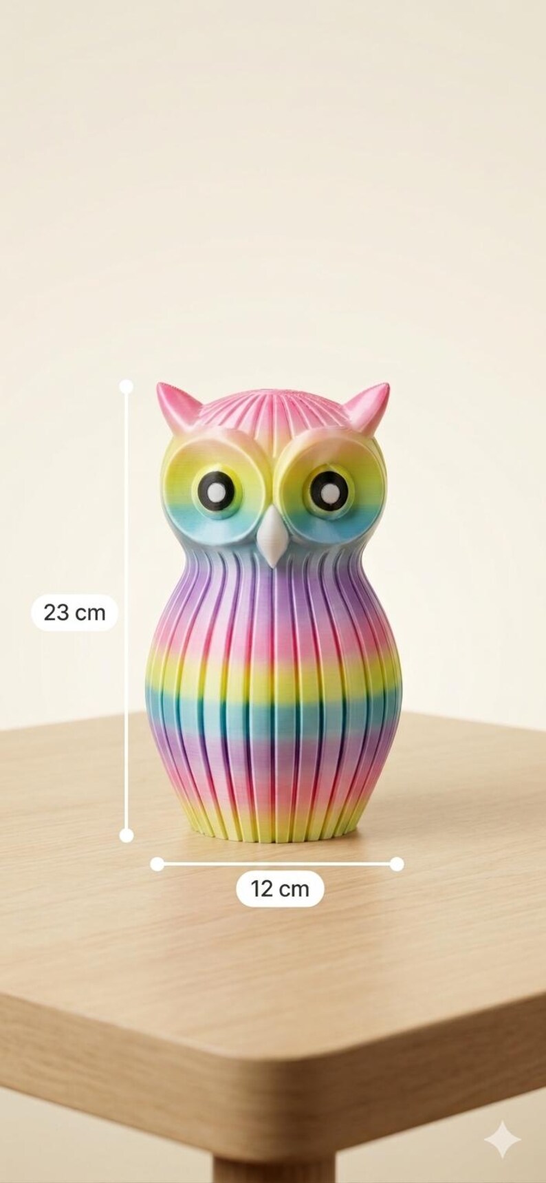 Puede incluir: Figura de b&uacute;ho colorida, de aproximadamente 23 cm de alto y 12 cm de ancho, con un dise&ntilde;o de rayas arco&iacute;ris. El b&uacute;ho tiene ojos grandes y peque&ntilde;as plumas en las orejas. La figura es de material liso y est&aacute; sobre una superficie de madera.