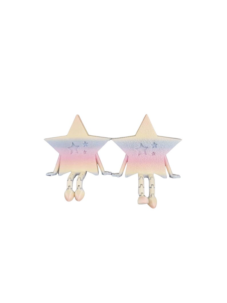 May include: Two star-shaped figurines with pastel rainbow coloring, holding hands. Each star has arms, legs, and feet, with small star details. The figurines are set against a white background.