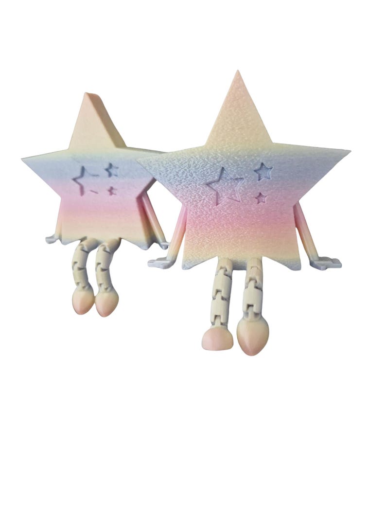 May include: Two whimsical star-shaped figurines with articulated legs and arms. The stars are pastel-colored, with shades of pink, blue, and yellow. Each star has a small star design etched on its surface. The figurines have a playful, cartoonish appearance.