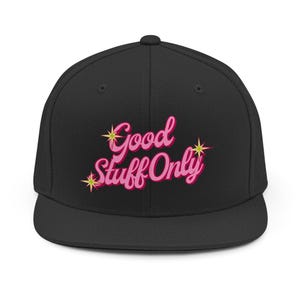 Puede incluir: Gorra de béisbol negra con visera plana, con la frase bordada "Good Stuff Only" en rosa. El texto está adornado con estrellas amarillas. La gorra tiene un ajuste estructurado.