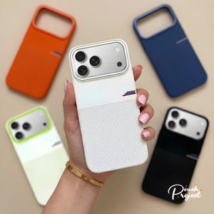 以下が含まれることがあります： オレンジ、青、白、黒、黄緑色のカラフルな携帯電話ケースのコレクション。 白いケースは手で持たれており、穴あきデザインと小さなロゴが特徴です。 ケースは洗練されたモダンなデザインです。