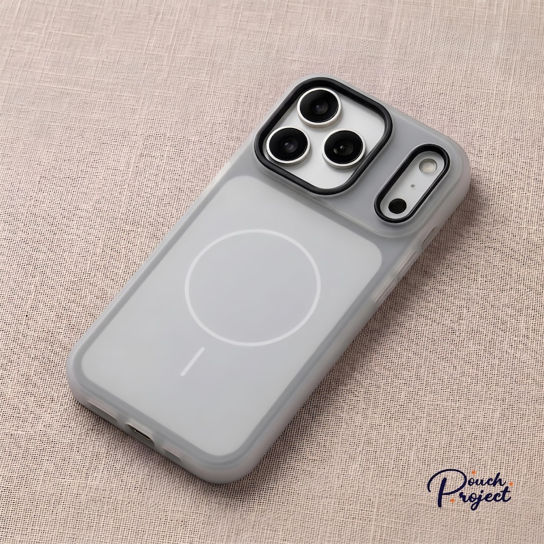 Pu&ograve; includere: Una custodia per telefono grigia trasparente con una cornice nera per la fotocamera e un cerchio bianco sul retro. La custodia ha un design elegante e moderno ed &egrave; realizzata in materiale resistente. Protegge il telefono da graffi e danni.