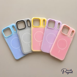 Pu&ograve; includere: Una collezione di cinque custodie per telefoni dai colori pastello in tonalit&agrave; di blu, grigio, giallo, viola e rosa. Ogni custodia ha una cornice colorata abbinata e un design circolare bianco sul retro. Le custodie sono disposte su uno sfondo neutro.