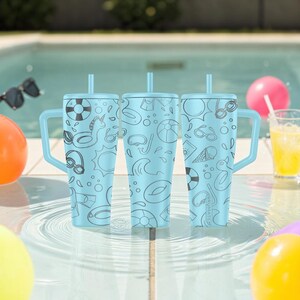May include: Three light blue insulated tumblers with handles and straws, featuring a repeating black line art pattern of summer pool items including life rings, goggles, suns, waves, ice cream cones, and inflatable pool floats with the text BRUMATE.