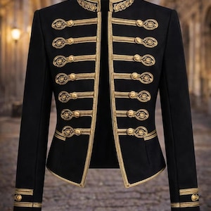 Puede incluir: Chaqueta negra con ribetes y botones dorados. La chaqueta presenta un cuello alto y detalles dorados en los bordes y puños. Una prenda elegante y entallada, adecuada para ocasiones formales, de inspiración militar.