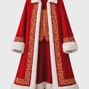 May include: A red velvet coat with white faux fur trim and gold embroidered detailing. The coat features a matching vest and dress, displayed on a wooden stand. A festive costume for holiday events.