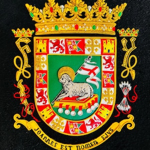May include: Embroidered crest with a gold crown, red and yellow accents, and the text "JOANNES EST NOMEN EJVS" on a black background. The crest features a lamb, flags, and other heraldic symbols.