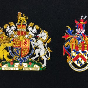 May include: Two embroidered patches on black fabric. The left patch features a royal coat of arms with a lion and unicorn, a shield, and the text "DIEU ET MON DROIT." The right patch displays a different coat of arms with a stag and the text "PER SAPIENTIAM CONSTANTIAMQUE VICTORIA."