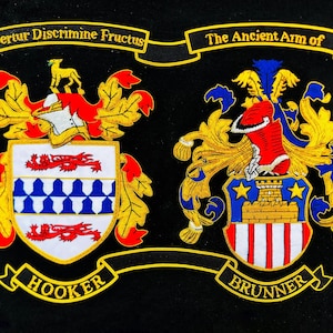 May include: Embroidered crests of the Hooker and Brunner families on a black background. The crests feature shields with intricate designs, including a golden deer, red dragons, and blue and white patterns. Text includes "Fertur Discrimine Fructus" and "The Ancient Arm of".