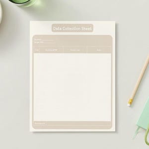 May include: A cream-colored Data Collection Sheet with a light brown border and text. A pencil, a green notebook, and a set of keys are on the right. A bowl of green grapes and a glass of water are in the upper left.