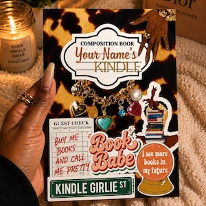 Peut inclure: Un cahier de composition avec un motif léopard marron et noir. La couverture présente le texte "Your Name's Kindle" et plusieurs autocollants, dont "Book Babe" et "Kindle Girlie St". Un bracelet de charme avec des breloques en forme de cœur et de pierres précieuses est suspendu à la couverture.