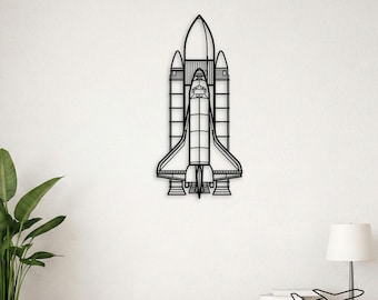 Op de afbeelding: Een zwart metalen wanddecoratie in de vorm van een spaceshuttle, met een gedetailleerde omtrek van de orbiter, de externe brandstoftank en twee vaste raketboosters. Het ontwerp bestaat uit strakke, dunne lijnen die de structuur van het vaartuig vormen.