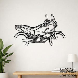 May include: A black metal wall art piece depicting the side profile of an adventure motorcycle. The design features clean, continuous lines outlining the frame, seat, handlebars, and wheels of the bike, creating a minimalist silhouette.