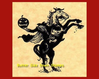 May include: Black and white illustration of a headless horseman riding a rearing horse, holding a jack-o'-lantern. The image is on a beige background with the text "Butter Side Down Stamps" in yellow.