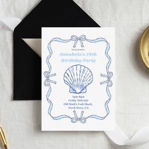 Op de afbeelding: Een witte uitnodigingskaart met een blauw zeeschelpontwerp en de tekst "Annabela's 14th Birthday Party". De kaart is omlijst met blauwe linten en strikken. Een zwarte envelop is zichtbaar op de achtergrond.