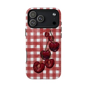 May include: A phone case with a red and white gingham design and a watercolour illustration of cherries. The cherries are a deep red colour and appear freshly picked. The case has a black camera module.