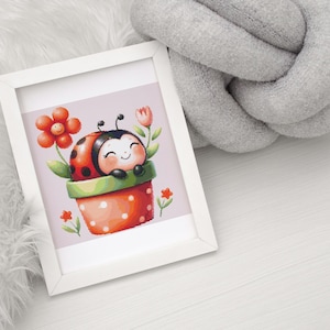 May include: A framed watercolour print showing a smiling ladybug in a red and white polka-dotted flower pot. The ladybug is surrounded by flowers and greenery, set against a light pink background. The frame is white.