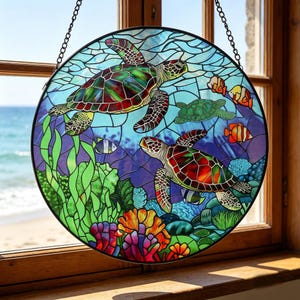 Pode incluir: Arte de janela redonda em vitral com tartarugas marinhas, peixes e corais. As tartarugas têm cascos vermelhos, verdes e castanhos. O fundo é azul e verde, com uma moldura de metal preta e corrente para pendurar.