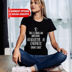 Puede incluir: Una camiseta negra de manga corta con un gráfico de flecha blanca apuntando hacia arriba y el texto: THIS IS WHAT AN AWESOME GENERATIVE AI ENGINEER LOOKS LIKE! Una pancarta roja en la esquina superior izquierda muestra: 5 GARMENT OPTIONS 15 DESIGN CONCEPTS.