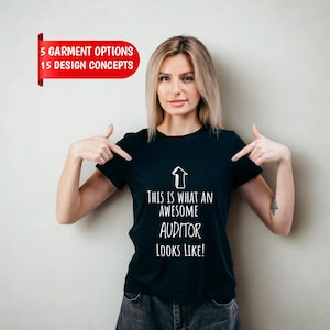 May include: A black short-sleeved t-shirt featuring a white upward-pointing arrow graphic and the text "THIS IS WHAT AN AWESOME AUDITOR LOOKS LIKE!" A red banner in the upper left corner displays the text "5 GARMENT OPTIONS 15 DESIGN CONCEPTS."