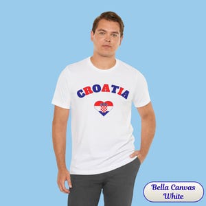 Model wearing a unisex Croatia shirt featuring a modern design with a heart-shaped Croatian flag detail on the chest. The look combines an aesthetic with a clean and minimal style. Suitable for both match days and everyday wear, this shirt offers a comfortable and versatile option for fans supporting Croatia, with a subtle yet distinctive expression of national pride.