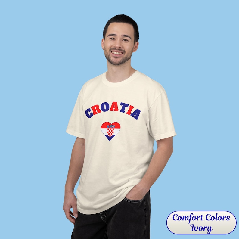 Model wearing a unisex Croatia shirt featuring a modern design with a heart-shaped Croatian flag detail on the chest. The look combines an aesthetic with a clean and minimal style. Suitable for both match days and everyday wear, this shirt offers a comfortable and versatile option for fans supporting Croatia, with a subtle yet distinctive expression of national pride.