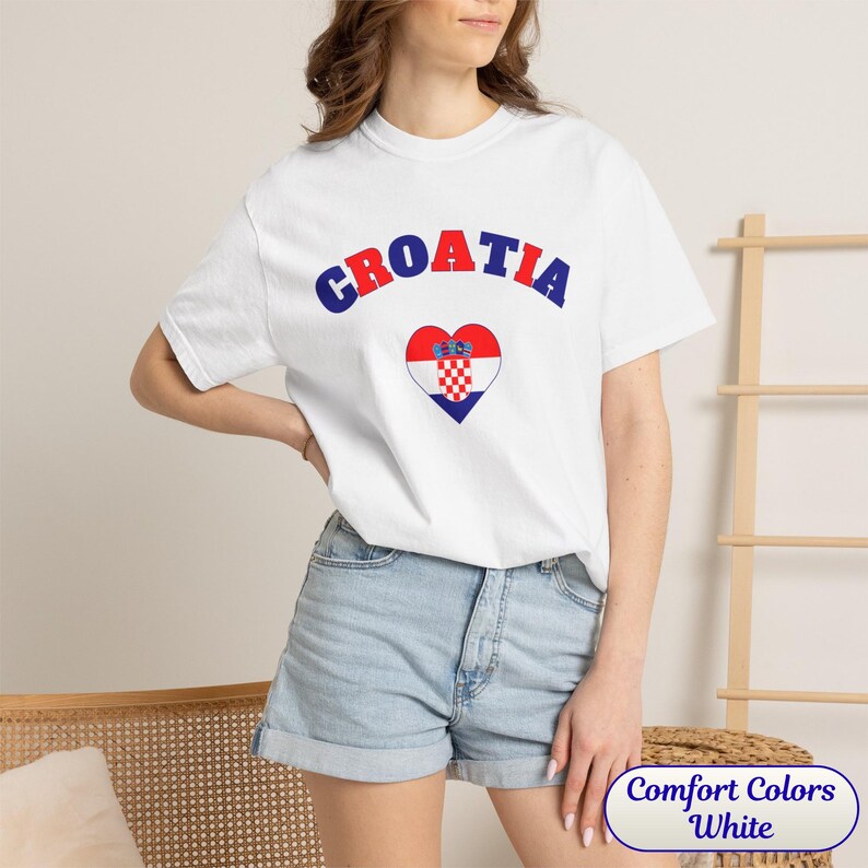 Model wearing a unisex Croatia shirt featuring a modern design with a heart-shaped Croatian flag detail on the chest. The look combines an aesthetic with a clean and minimal style. Suitable for both match days and everyday wear, this shirt offers a comfortable and versatile option for fans supporting Croatia, with a subtle yet distinctive expression of national pride.