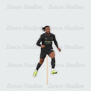 May include: A sticker featuring a cartoon illustration of a soccer player in a black uniform with the text "ETIHAD AIRWAYS". The player is wearing black shorts, socks, and shoes with green accents. The sticker is attached to a wooden stick.