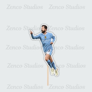 May include: A light blue soccer player sticker with the text "Etihad Airways" on the jersey. The sticker is on a wooden stick. The player is pointing with his right hand.